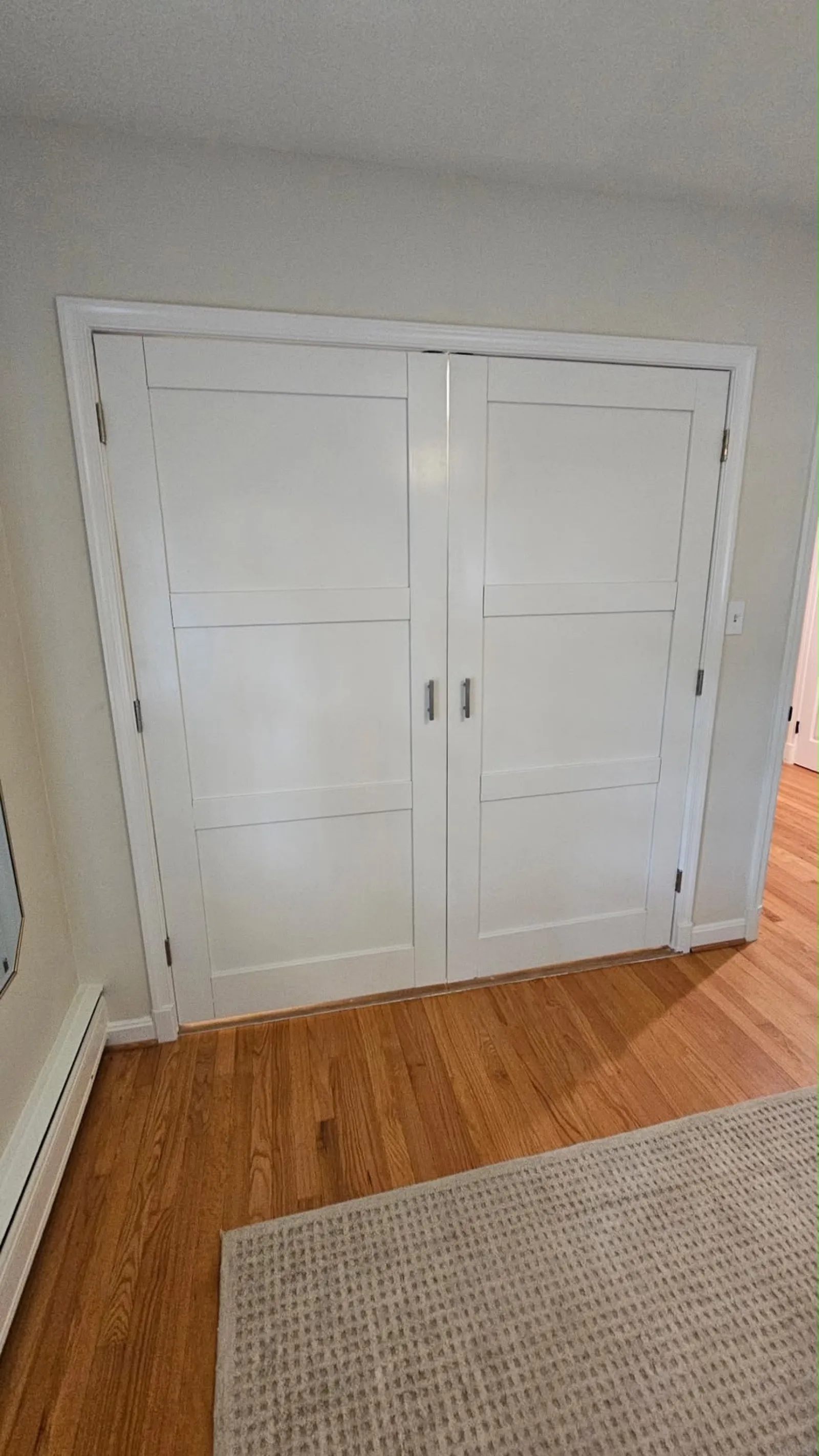 New white bifold closet doors installed and painted in a bedroom