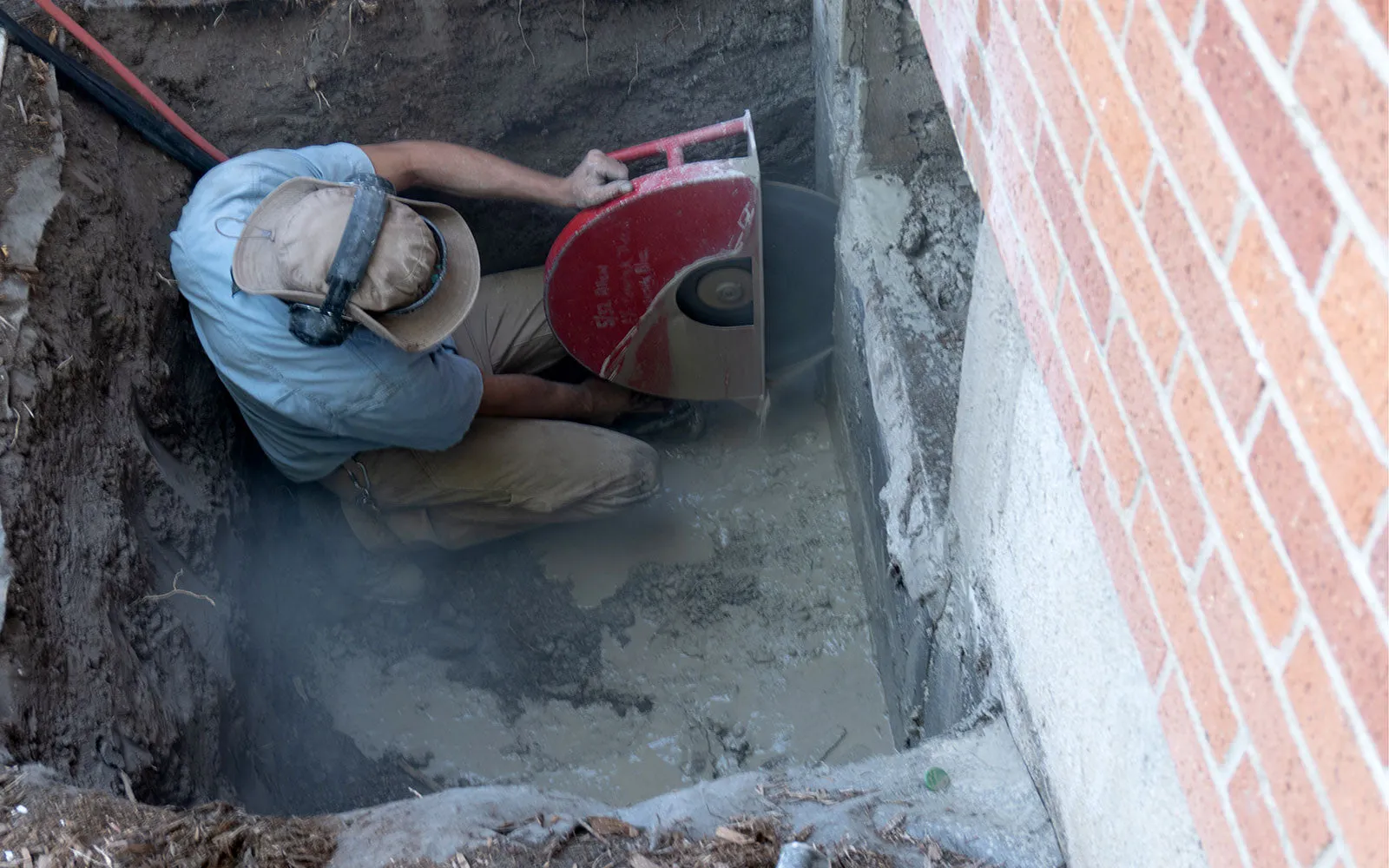 Concrete saw cutting a basement foundation wall for a new egress window opening