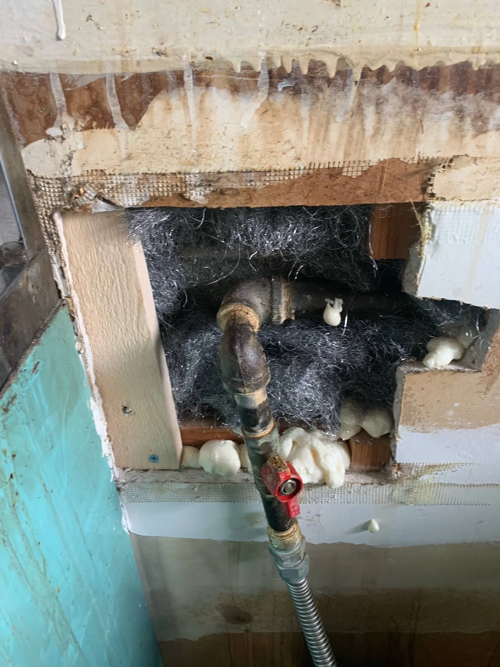 Ceiling opened up around a leaking pipe before the ceiling drywall repair